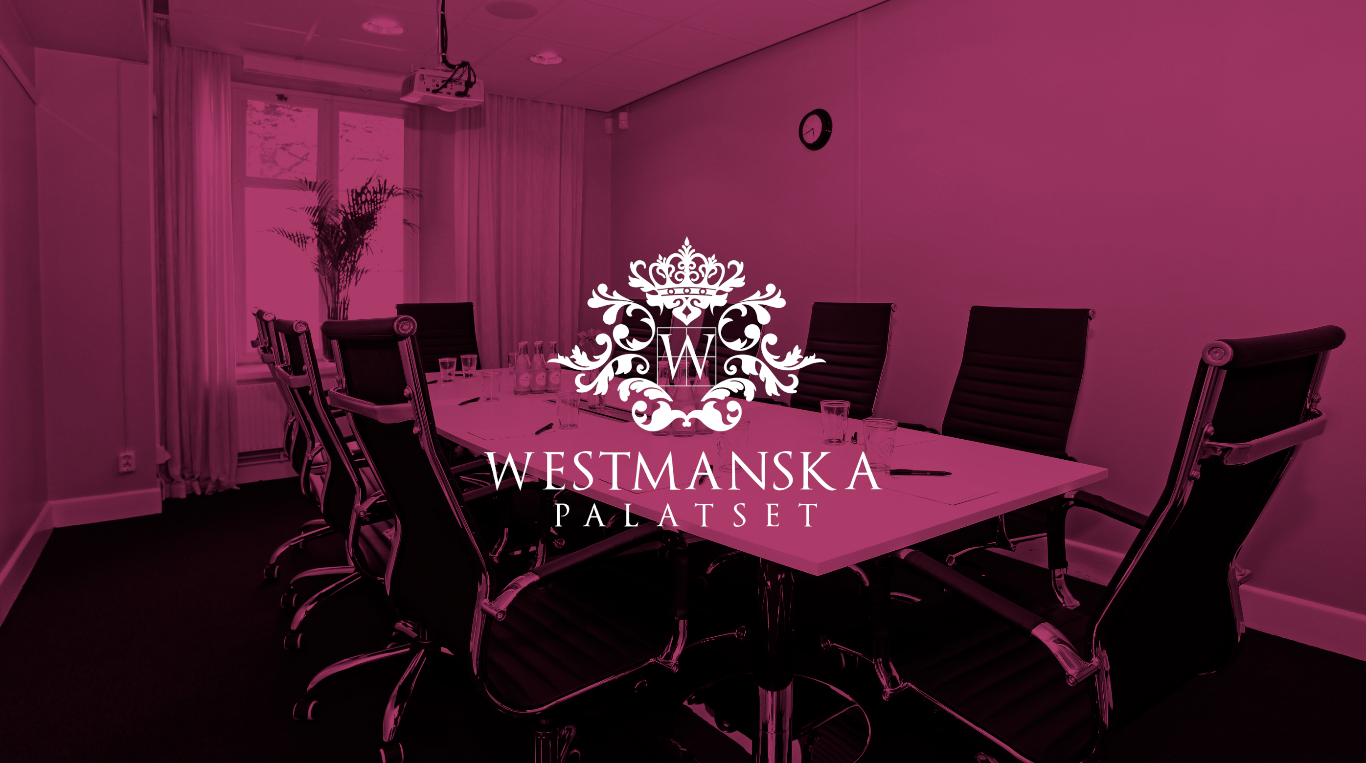 Ett mötesrum med ett stort bord, stolar och en dekorativ logotyp med texten "Westmanska Palatset"