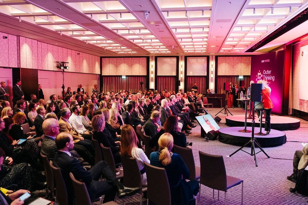 Dynamisk scen på Outer Thinking Summit 2023 med ett fullsatt rum av engagerade svensk-brittiska gäster och åhörare.